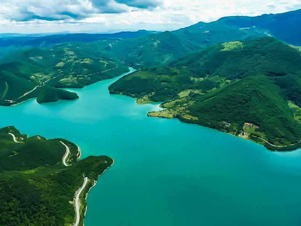 Aerial view of the turquoise waters and wooded hills of Liqeni i Ujmanit